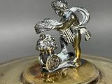 a silver plate with a figurine of a boy and a dog on it