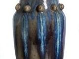 a blue and gold vase sitting on top of a table