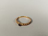 a close up of a gold ring with black stones on it