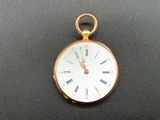 a gold pocket watch with roman numerals on the face