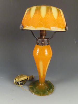 une lampe orange avec un pied vert et un abat-jour jaune