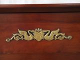 a wooden dresser with a brass decoration on it