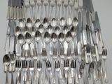 de nombreuses fourchettes et cuillères disposées sur la table