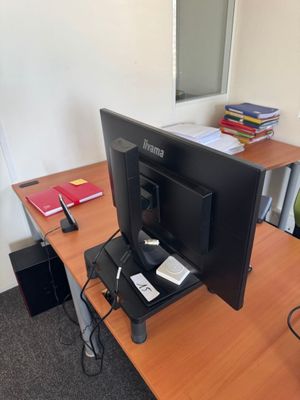 a computer monitor sitting on a desk in an office