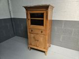 a small wooden cabinet with a glass door on top of it