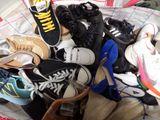 many pairs of shoes that are piled together on a bed