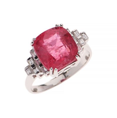 a close up of a ring with a pink stone surrounded by diamonds