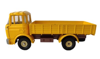 un petit camion jaune posé sur une surface blanche
