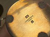 a close up of a person holding a pan with a logo on it