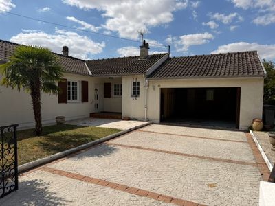 une allée menant à une maison avec un palmier dans le jardin devant la maison
