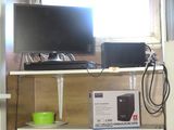 a shelf with a monitor, speakers, and other electronics on it