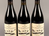 trois bouteilles de vin posées sur une table l'une à côté de l'autre