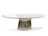 a round glass table with a metal base and a circular glass top