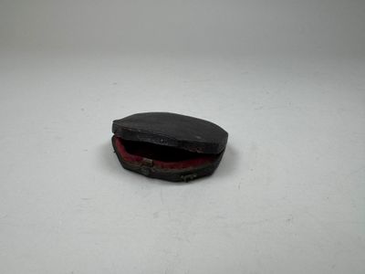 un petit objet noir sur une surface blanche