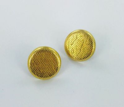 a pair of gold tone metal buttons on a white surface