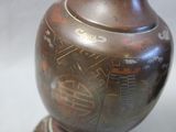 a brown vase with designs on it sitting on a table