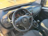 the interior of a small car with a steering wheel and dashboard controls