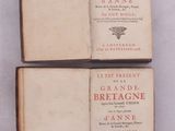 trois livres superposés sur une surface blanche