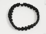 un bracelet composé de perles de lave noires sur un fond blanc