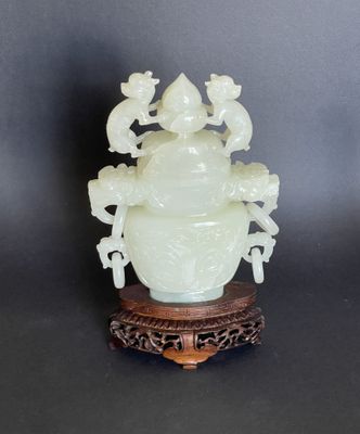 une image représentant un vase en jade blanc posé sur un socle en bois