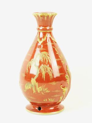 a red vase with a gold design on it