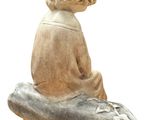 statue of a child sitting on a piece of wood with a fish on it
