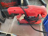 une ponceuse électrique rouge posée sur une table