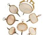 Plusieurs bijoux sont disposés en cercle sur une surface blanche