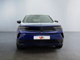 a blue car parked in a room with a white wall