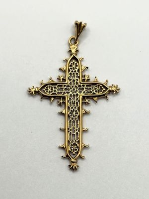 a gold cross pendant on a white background