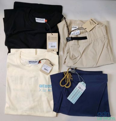 Trois paires de pantalons pour homme et un t-shirt sont posés sur une table