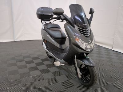 un scooter garé sur un sol à carreaux noirs et blancs