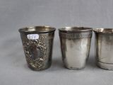 three silver cups sitting next to each other on top of a table