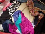 a pile of clothes sitting on top of a bed