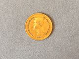 a close up of a gold coin on a gray surface