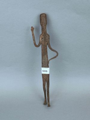 une petite statue représentant un homme tenant une pancarte à la main