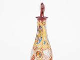 a glass vase with a bird on it on a white surface