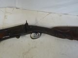 un vieux fusil avec un canon en bois et une poignée en bois