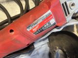 a red electric drill sitting on top of a piece of metal