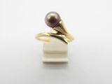 un gros plan d'une bague ornée d'une perle violette