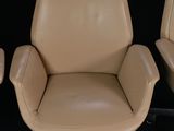 three leather office chairs sitting next to each other on a black surface