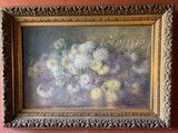 un tableau représentant des fleurs, dans un cadre doré, accroché à un mur rose
