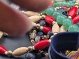 a close up of a person ' s hand holding a watch and a bunch of beads