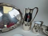 a silver plate with a silver pitcher and a silver plate with a silver plate and a silver plate with a silver plate and a silver plate with a silver