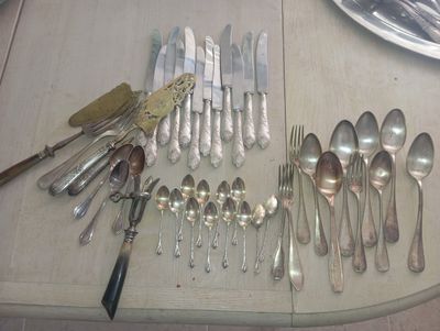 a lot of silver spoons and forks on the table