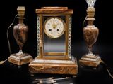 une horloge posée sur une table à côté de deux lampes