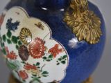 a blue vase with a gold decoration on it