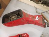 une paire de chaussures rouges posée sur une table, à côté d'une boîte à outils