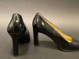 a pair of black high heeled shoes sitting on top of a table