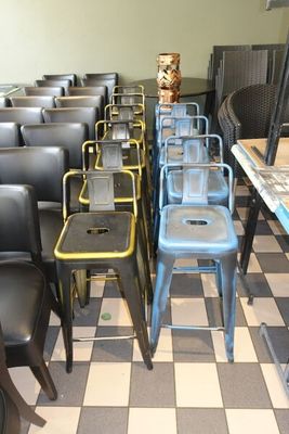 de nombreuses chaises et tables dans une pièce au sol à carreaux